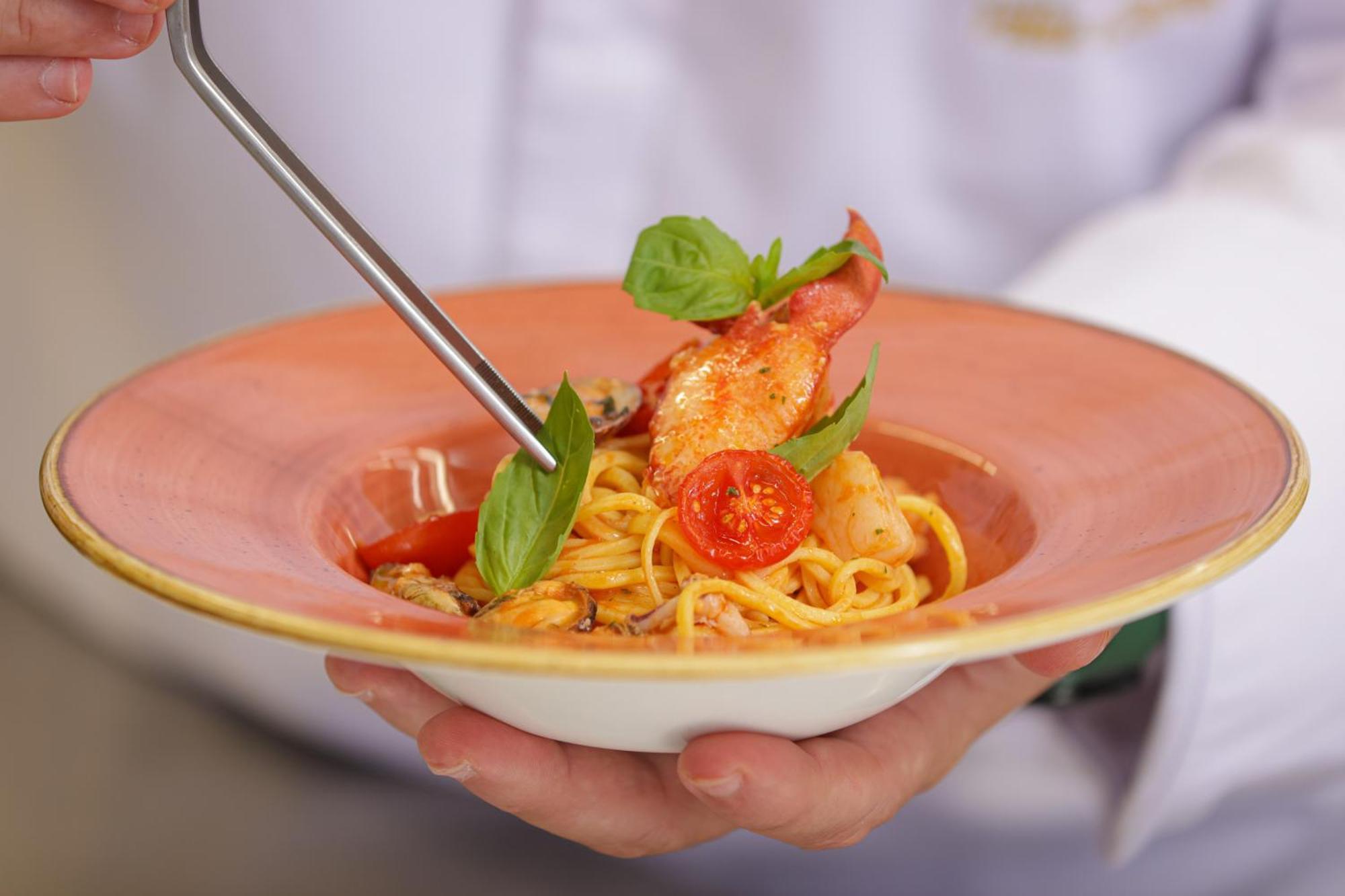 Grand Hotel Villa Castagnola Lugano Kültér fotó A chef finishing a pasta dish